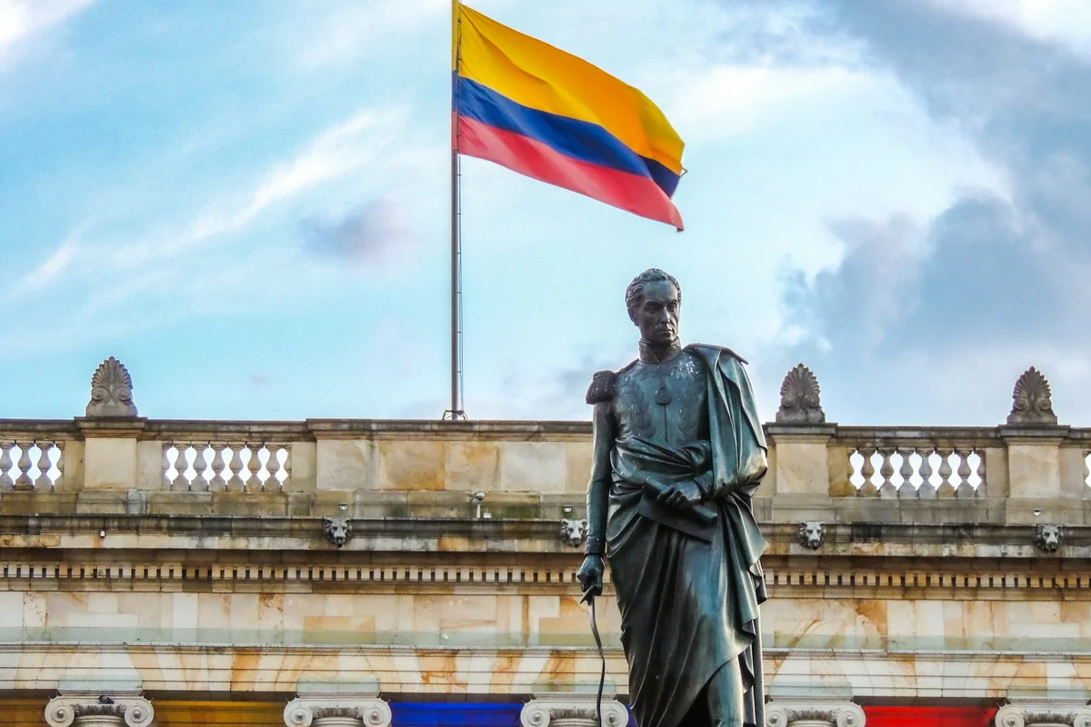 Estatua de Simón Bolívar frente al Capitolio Nacional con la bandera de Colombia